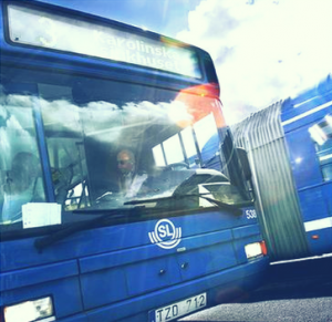 Front of blue painted bus with SL logo. Photo.