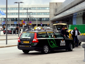 Tow taxi cars parked outside building. Photo.